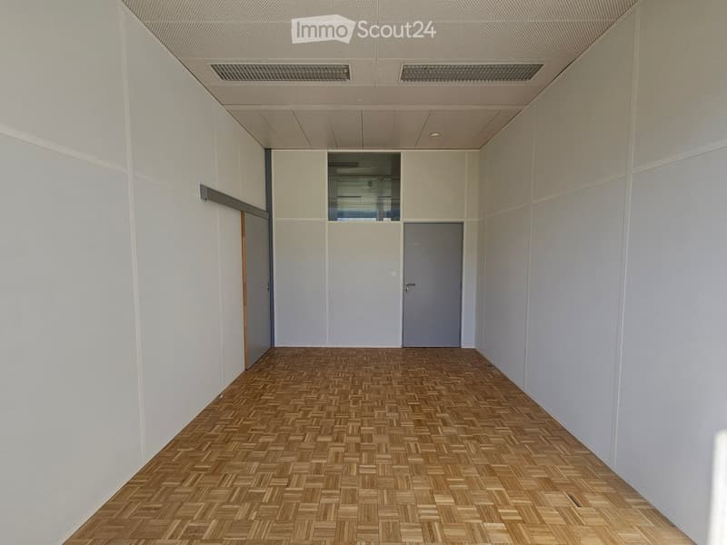 Empty room with wooden floor, two gray doors, and white walls