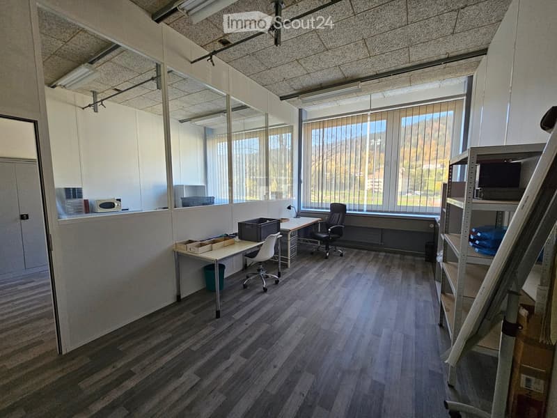 empty office room with two desks, office chairs, large windows, and mirrors