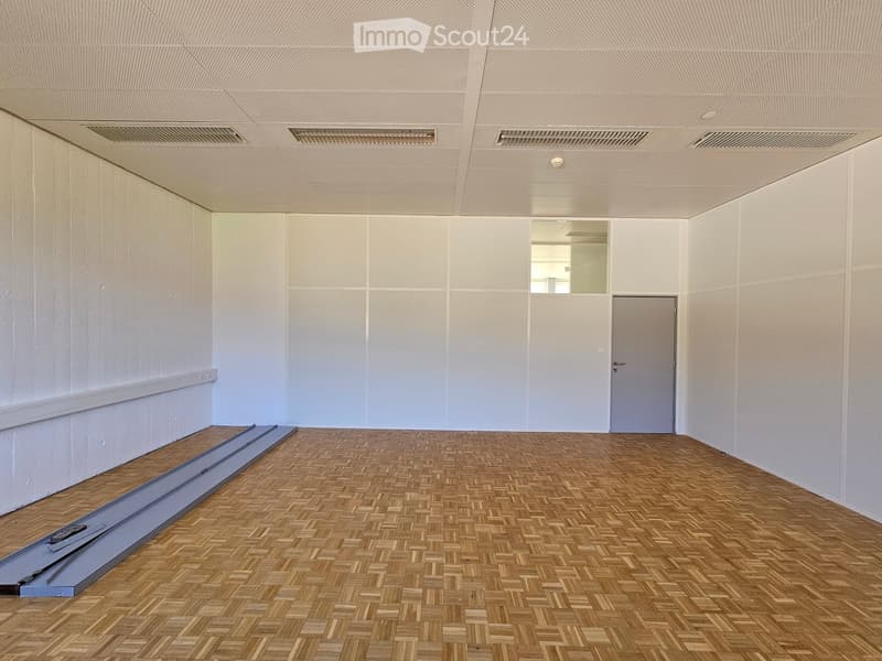 empty room with white walls, wooden floor, a door, a mirror