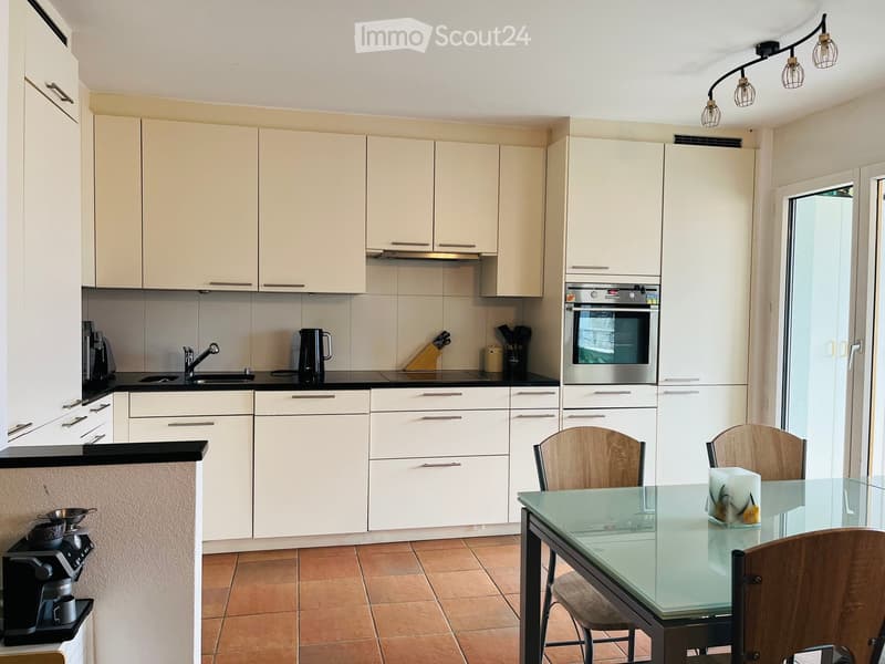 white cabinets, black countertop, stainless steel appliances, sink, oven, gas stove, kitchen table, chairs