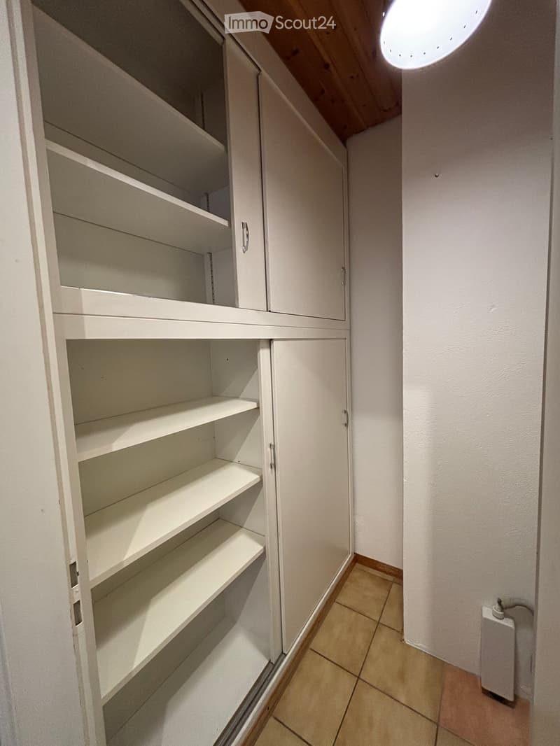 white cabinets, tiled floor, white walls, round ceiling light, large shelves