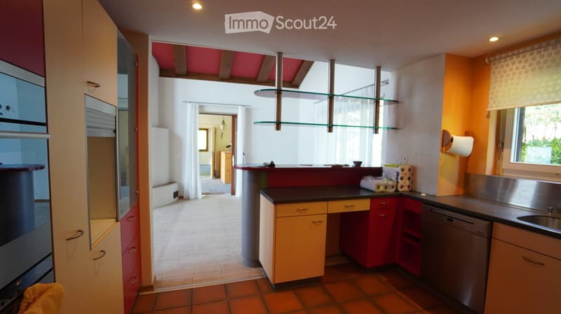 modern kitchen with glass shelves, red counter, stainless steel dishwasher, tiled floor, white windows
