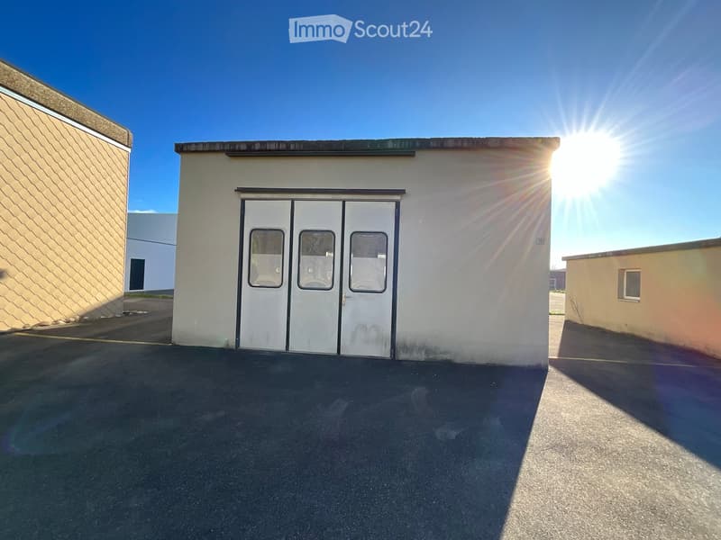 Warehouse, white building, double door entrance, paved parking area