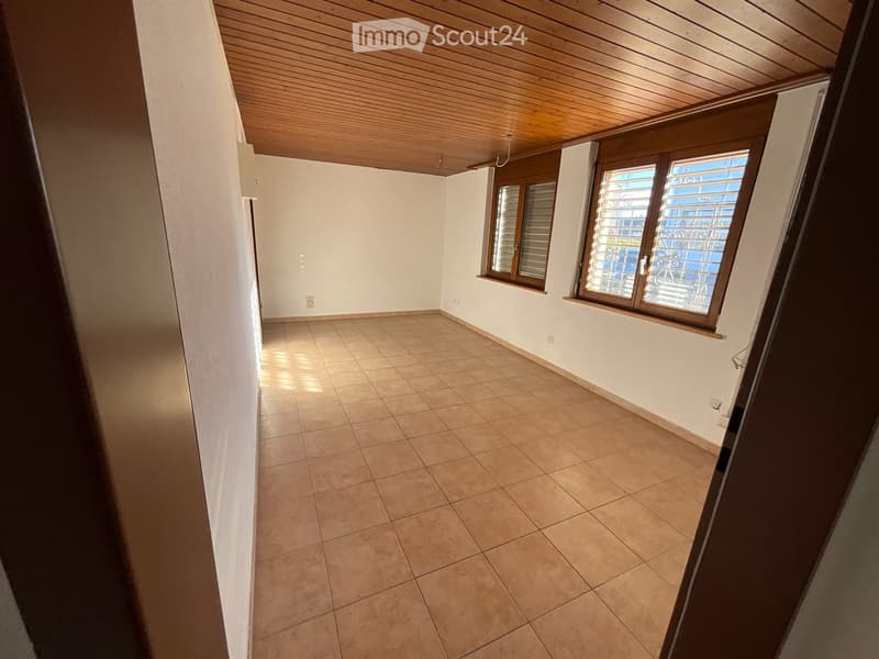 empty room, white walls, wooden ceiling, tiled floor, two windows with shutters, power outlets