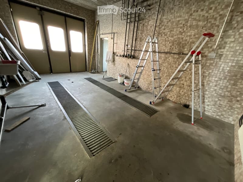 industrial room, double doors, tiled wall, open area, ladder, buckets, trolley