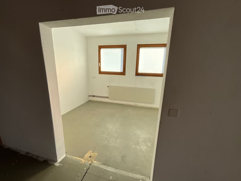 Empty room with two windows and a radiator between them