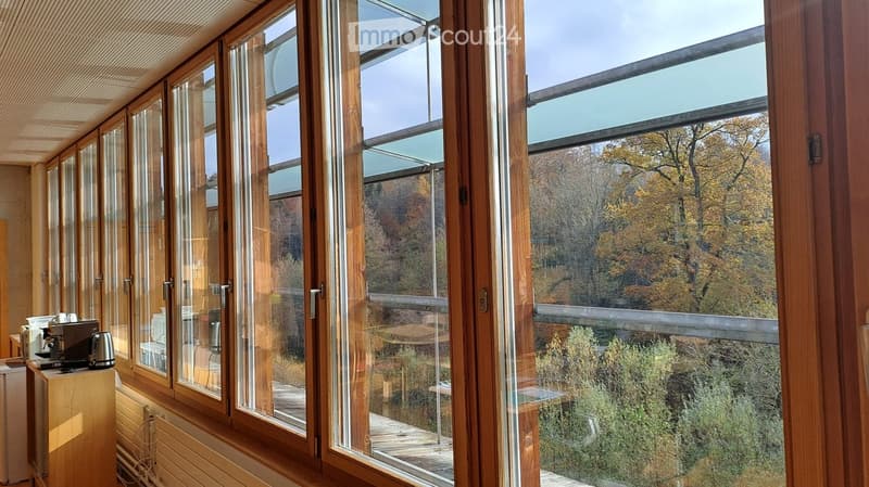 large windows, balcony, view of forest