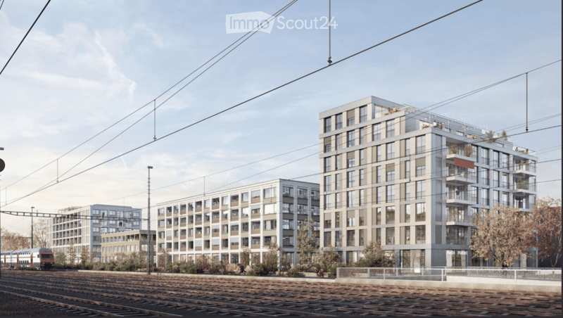 Three multistory buildings with many windows, ground level, balconies on top floors, adjacent to railway tracks