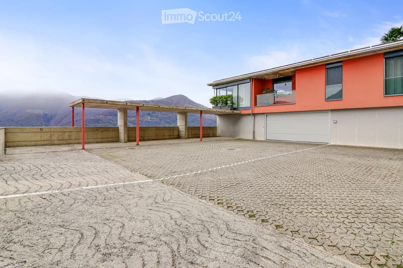 Modern building with a garage and parking in front, red and white walls, concrete structure, railings