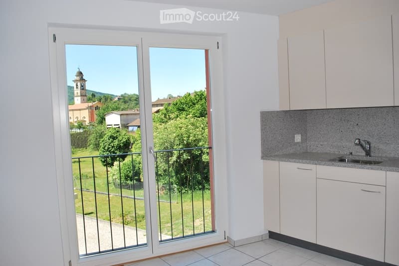 sliding glass door to balcony, modern kitchen, granite countertop, stainless steel faucet, white cabinets, power outlet