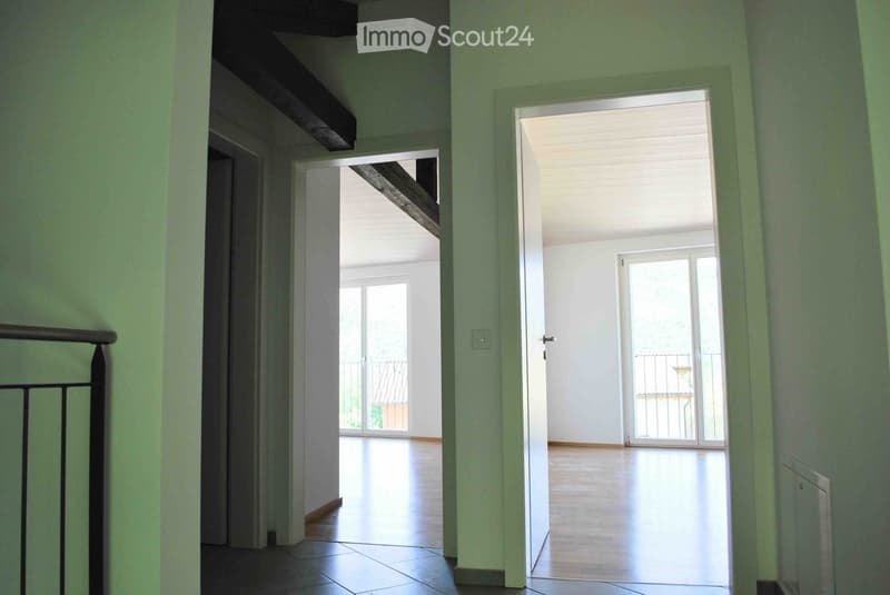 Corridor with two open doors, tile floor, balcony with railing visible in one of the rooms