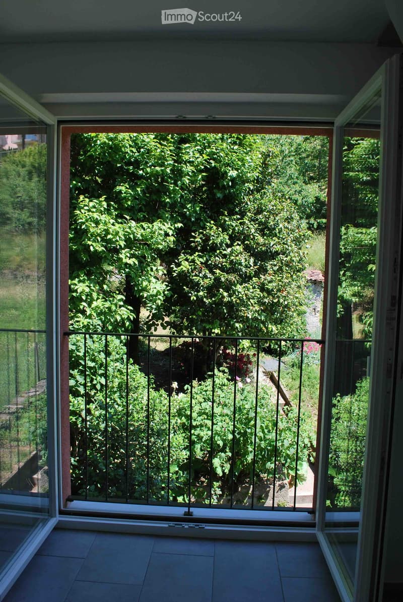 Balcony overlooking a green landscape, with plants and trees
