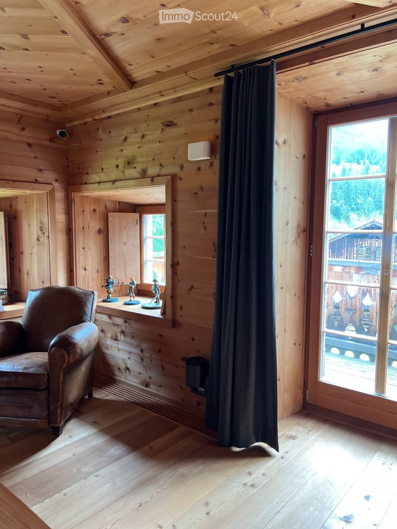 leather chair, wooden walls, open window, curtain, trash can, lamp, outdoor view