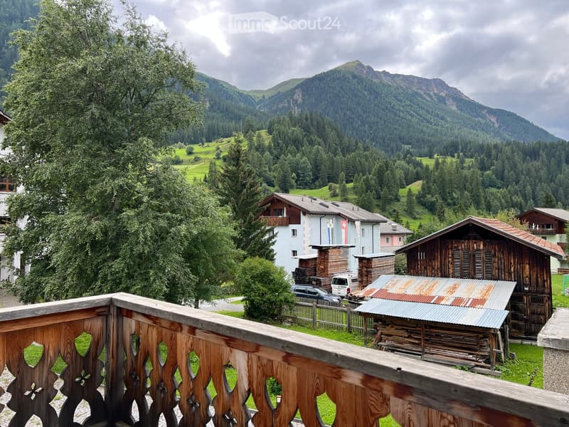 House: balcony, Swiss flag, mountain view, wooden architecture, cars parked