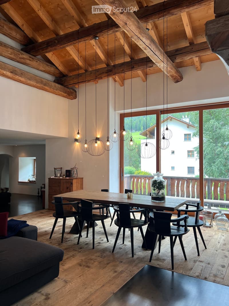 Exposed wooden beams, wooden floor, dining table with chairs, wooden cabinets, large glass doors, balcony, view of outdoor