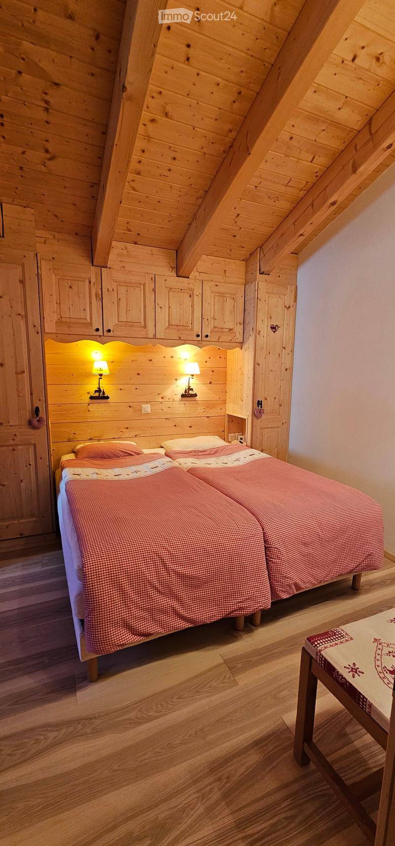 two twin beds, wooden walls, wooden shelves, wooden floor, lamps