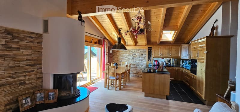 wooden beams, fireplace, stone wall, kitchen island, dining area, sliding door