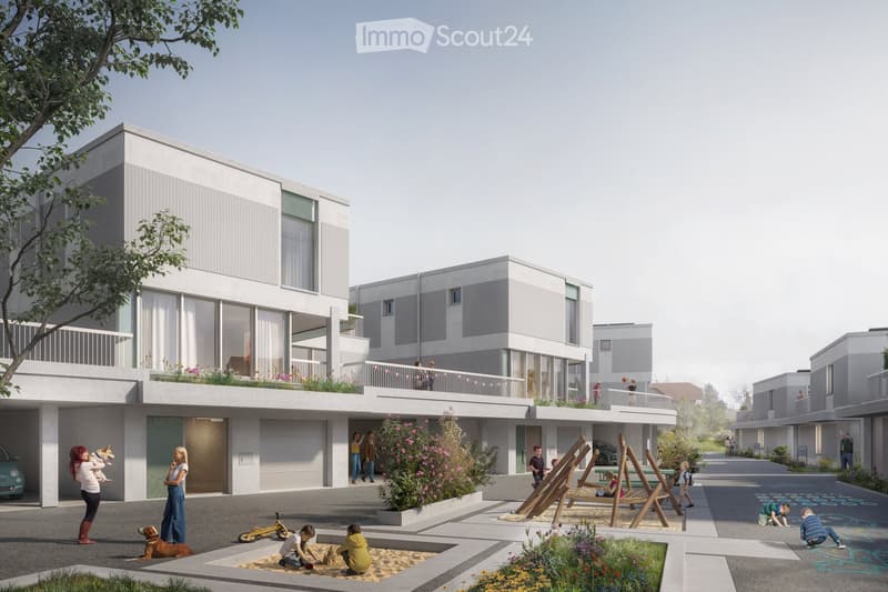 Building. Modern residential complex with multiple two-story buildings, balconies, and a communal outdoor area with children playing, greenery, and a small playground.