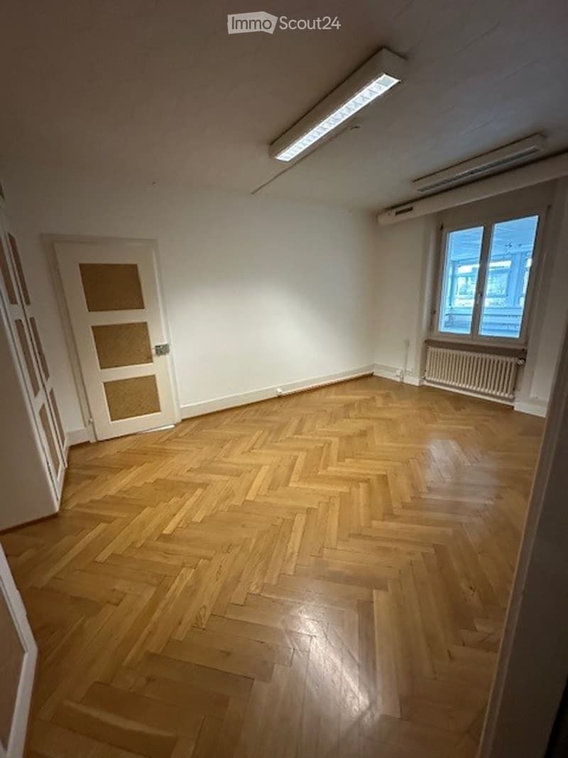 empty room, wooden floor, white walls, door, radiator, window