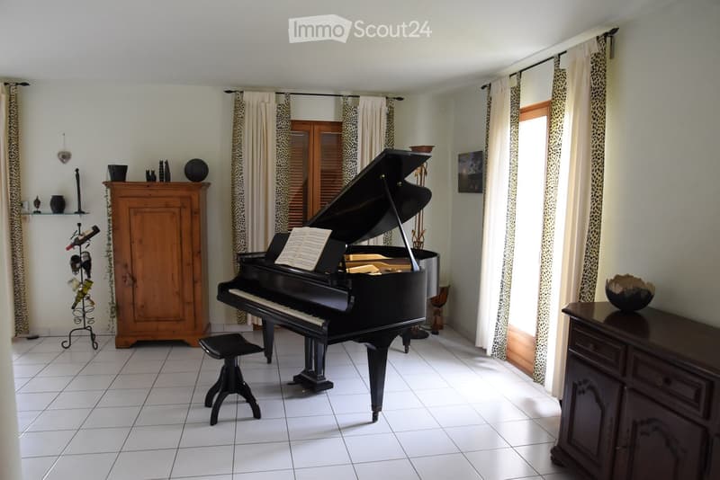 a grand piano, piano bench, wooden cabinet, wine rack, brown cupboard, tile flooring, curtains, a picture frame, wooden windows