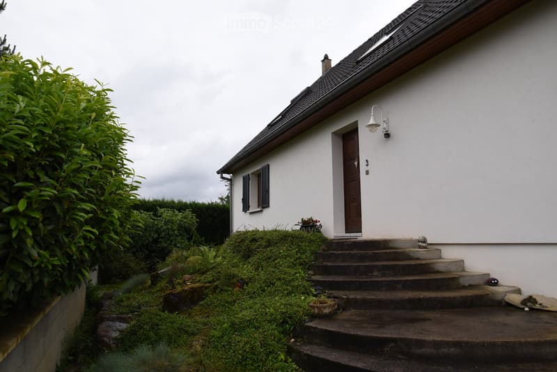White house, raised ground floor, concrete steps, garden, black windows