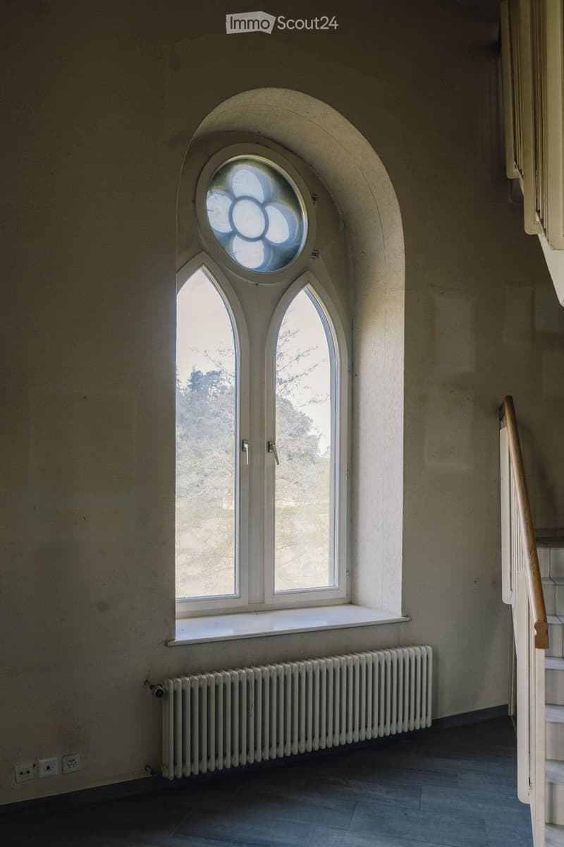 arch window, white radiator, wooden handrail, power outlets