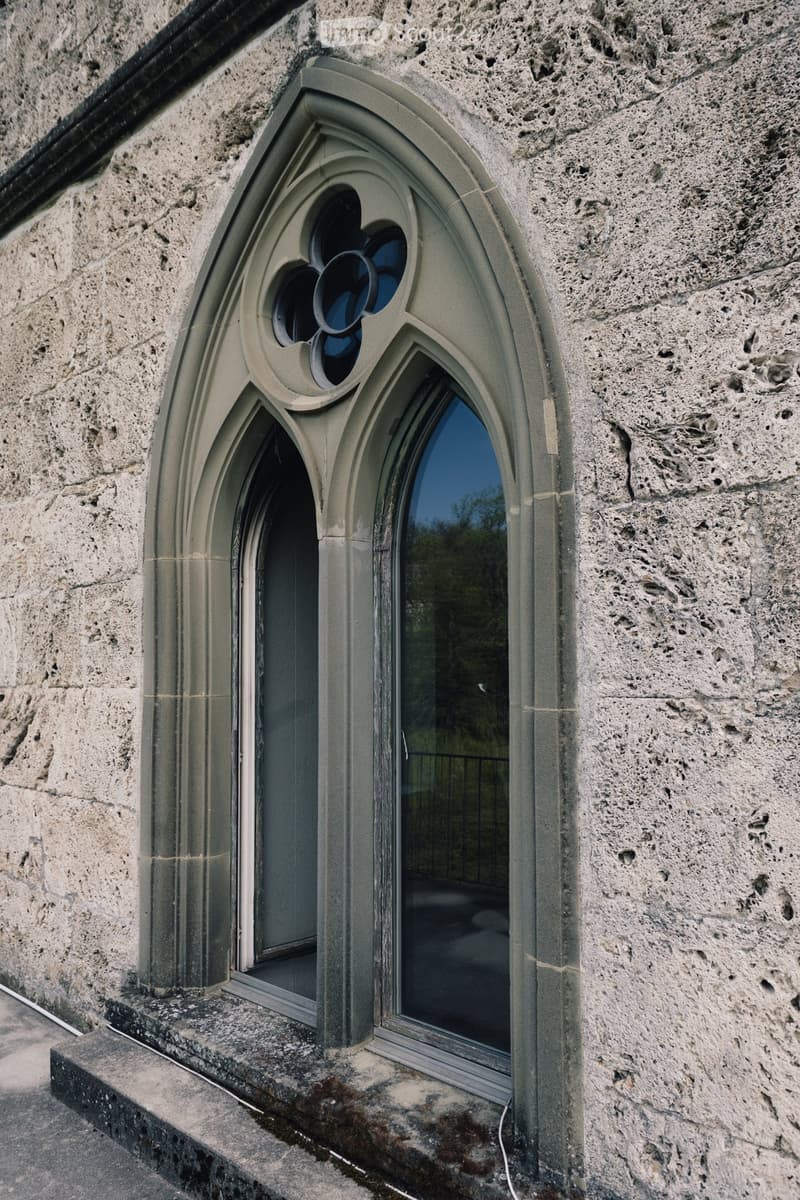 Gothic arch window with a flower design, made of stone, with glass panes