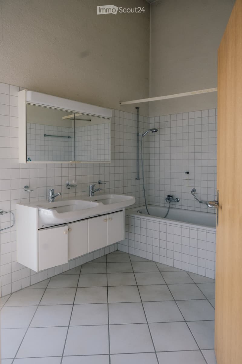Bathroom with white tiles, double sink, bathtub, mirror, and shower