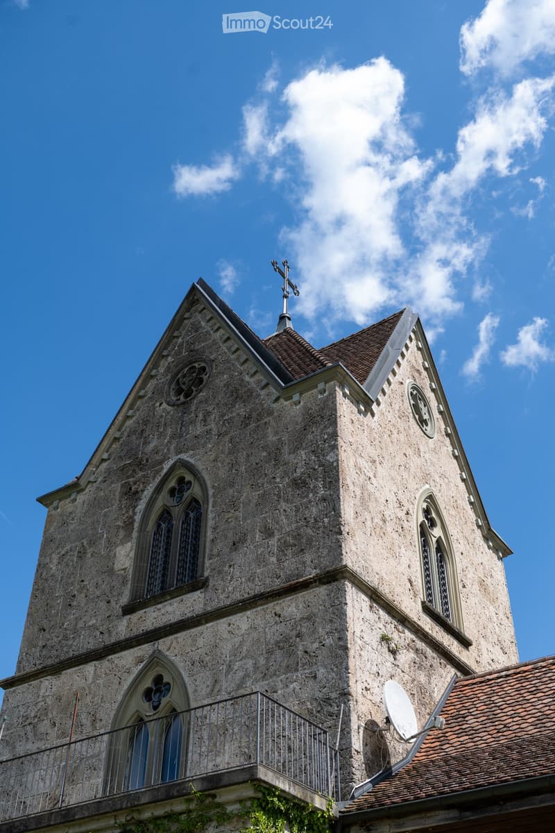 stone building, cross on top, balcony, satellite dish