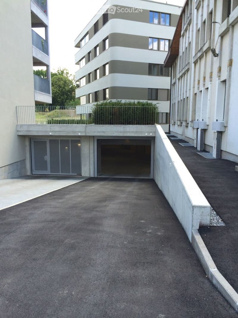 Rear view of underground garage with closed gate and sloped drive up