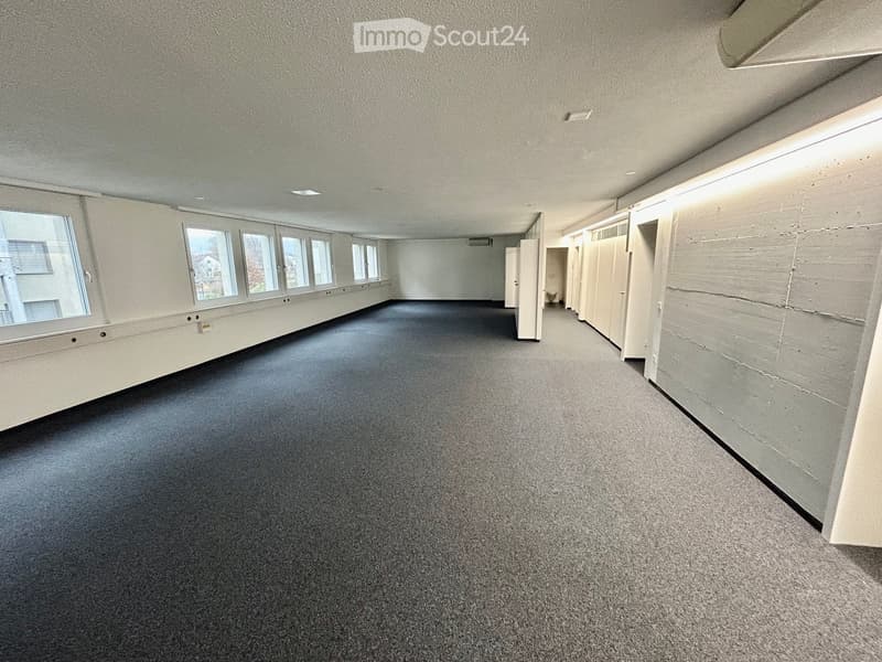 empty room with windows, carpeting, two doors at end of hallway