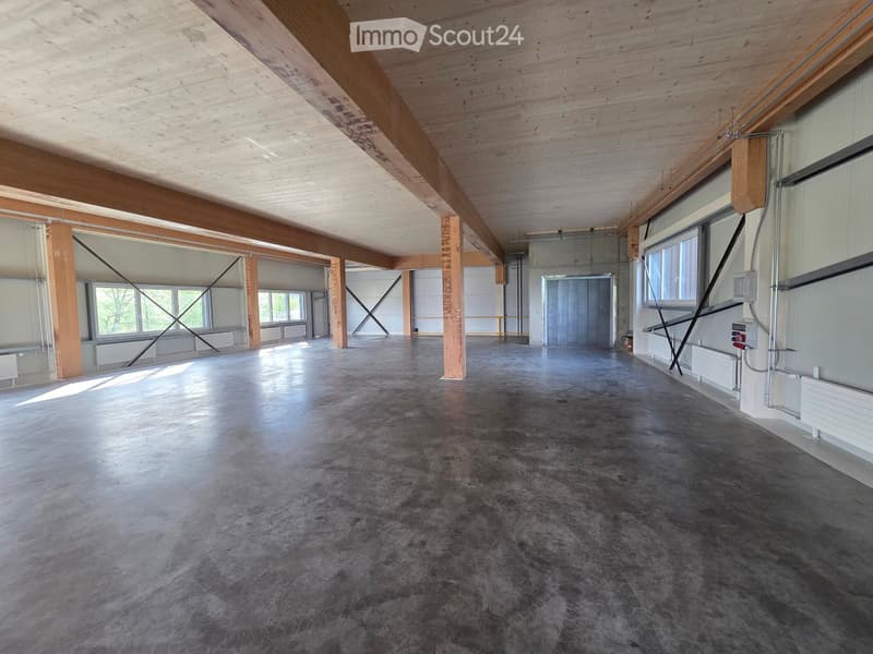 Empty room with concrete floor, wooden beams, and white walls. No furniture or equipment.