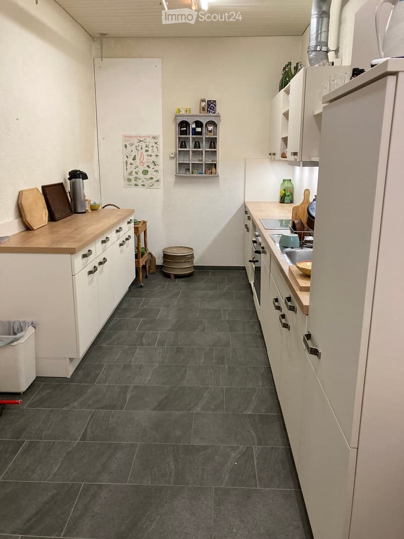 modern kitchen, large tiles, gray tiles, gray countertops, white cabinets, stainless steel gas stove, white appliances, storage space, small side table