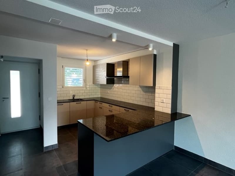 open kitchen, island, black countertop, wooden cupboards, white tiles