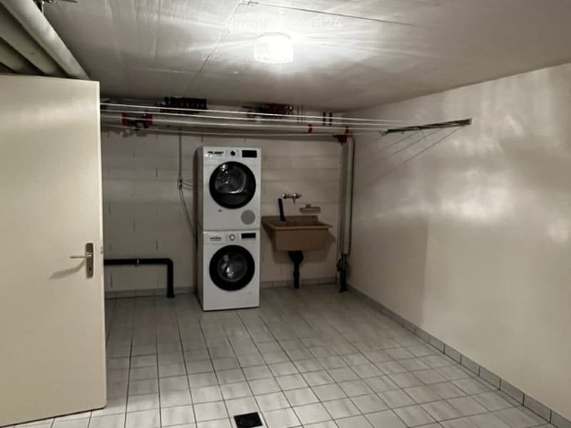 An underground laundry room with a washer, dryer, and sink.