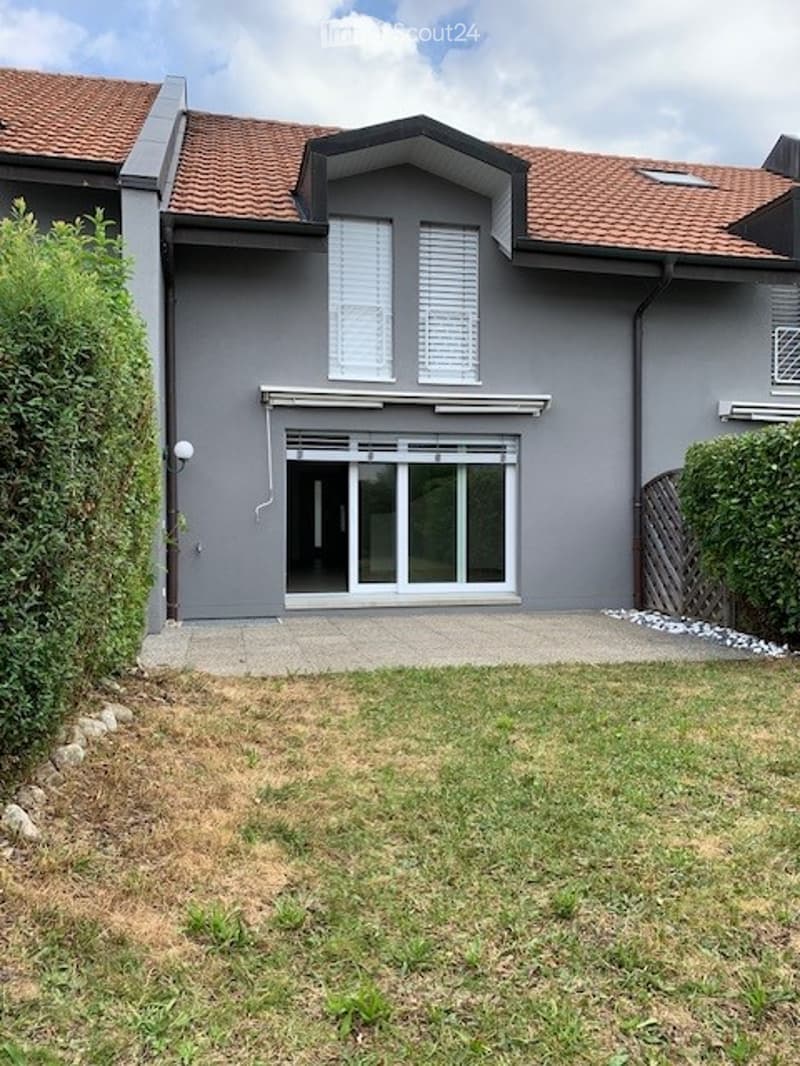 2-story gray house with red tile roof, large windows, garage, and parking space in the front yard