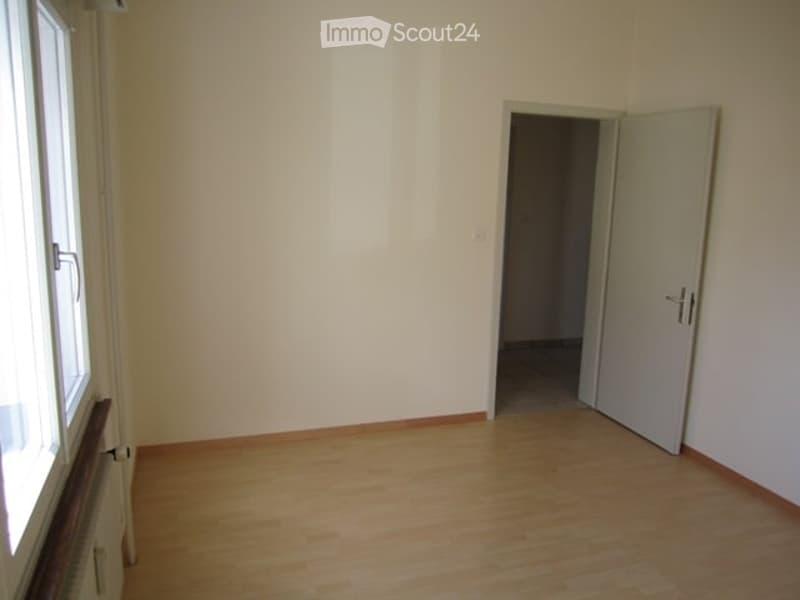wooden floor, white walls, windows, open door leading to another room
