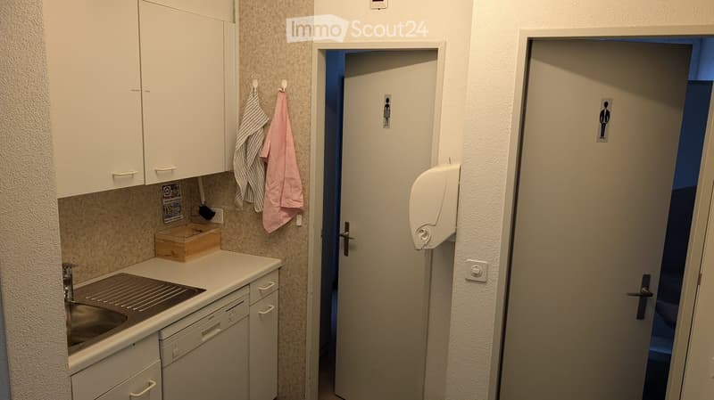 modern kitchen with white cabinets, granite countertop, stainless steel sink, dishwasher, and a box on the counter