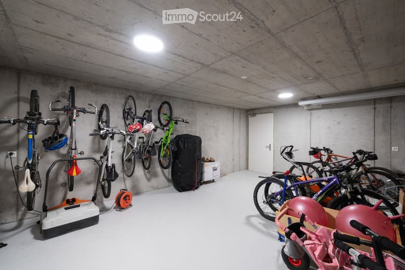 underground parking with bicycles, exercise equipment, and storage boxes