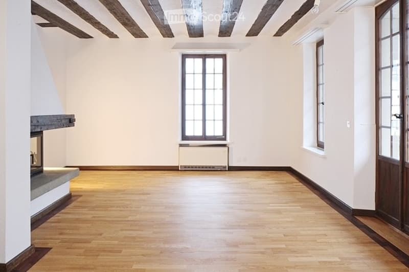 empty room with hardwood floor, fireplace, windows, white walls