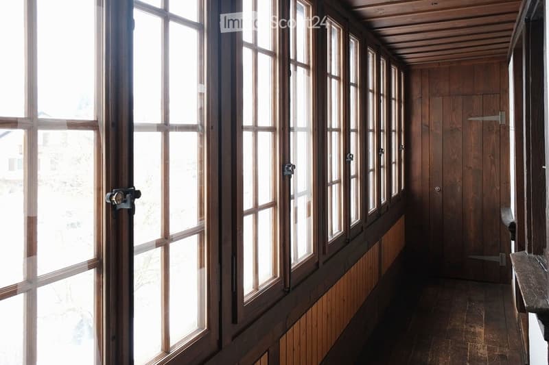 Large wooden window frames, wooden doors, wooden wall panelling, wooden floor.