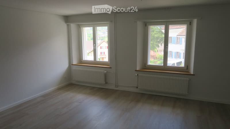 wooden floor, 2 windows, white walls, 2 white radiators, empty room