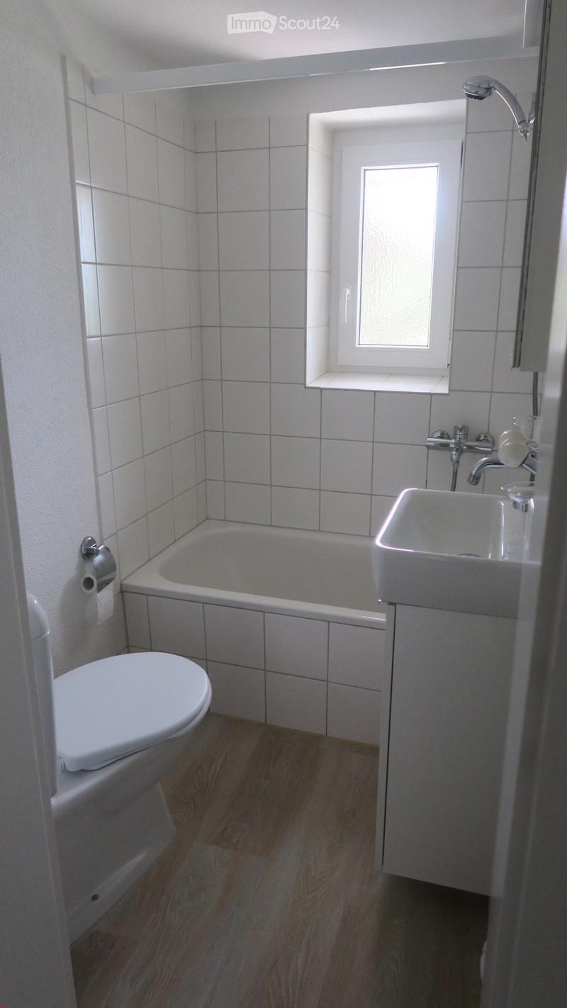 Small bathroom with toilet, bathtub, sink, window