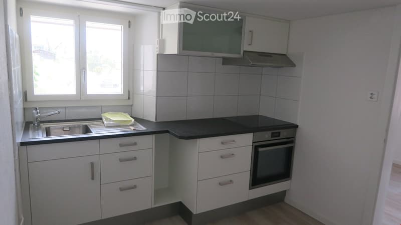 White kitchen, black countertop, stainless steel sink, oven, dishwasher, electrical outlets
