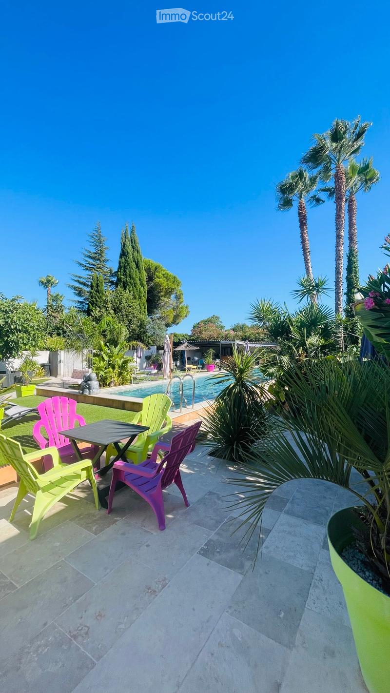 Outdoor dining table, plastic chairs, potted plants, swimming pool, blue sky