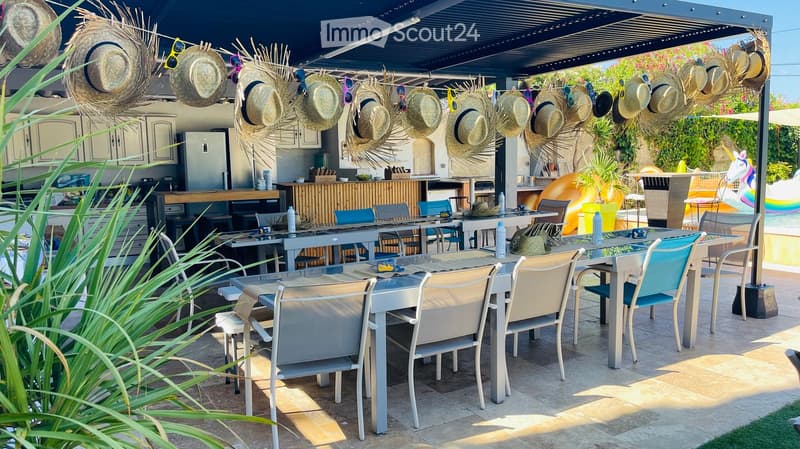 covered dining area, lots of hats, dining table with many chairs, refrigerator, umbrellas