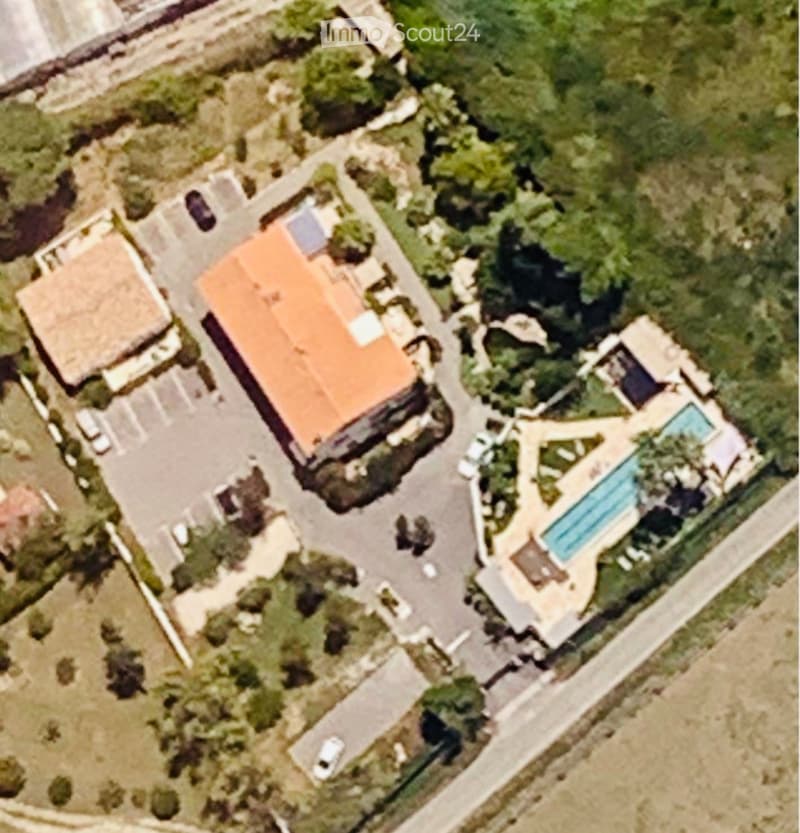 Large residential complex with a swimming pool and parking area