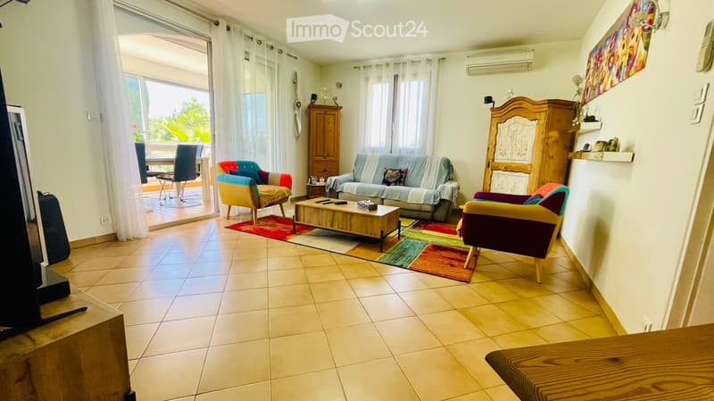 Terrace visible through sliding doors, beige tiles, wooden furniture, rug, couch, coffee table, chairs, wooden cabinets, air conditioner