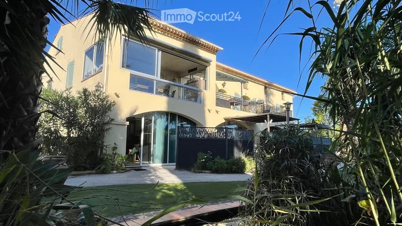 two story house, beige exterior, large windows, balcony, gated entrance, garden
