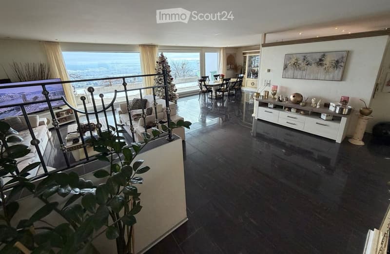 Spacious living area with a modern design, large windows, dining area, Christmas tree, fireplace, sofas, and a dining table